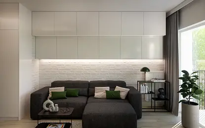 Wnętrze salonu w stylu industrialnym z szarym narożnikiem i białymi meblami.