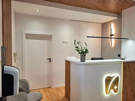 Wnętrze recepcji z industrialnym i skandynawskim stylem, białe meble, drewniane detale.