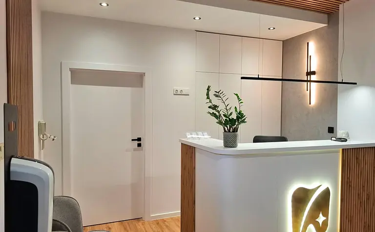 Wnętrze recepcji z industrialnym i skandynawskim stylem, białe meble, drewniane detale.