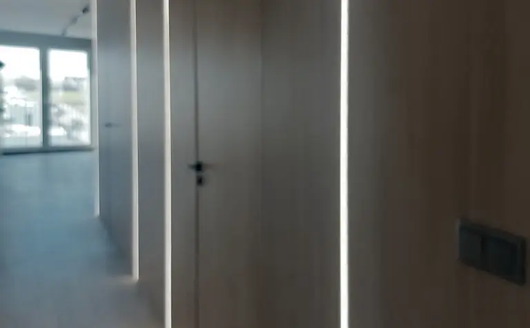 Korytarz w stylu industrialnym z drewnianymi ścianami i nowoczesnym oświetleniem LED.