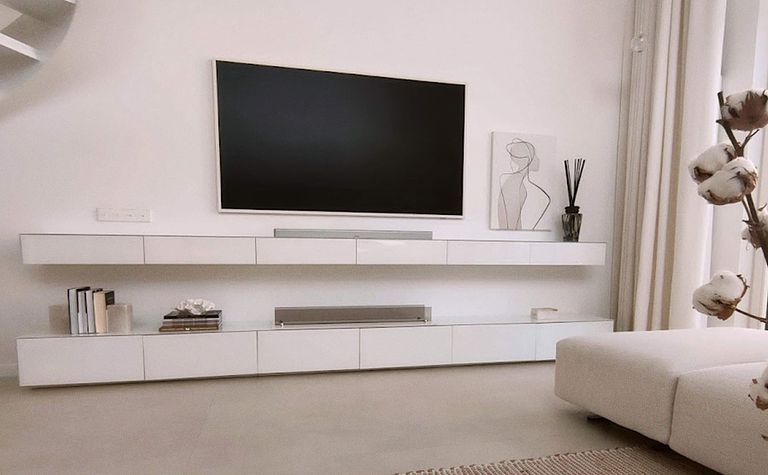 Wnętrze salonu w stylu minimalistycznym z białymi meblami i dekoracjami.