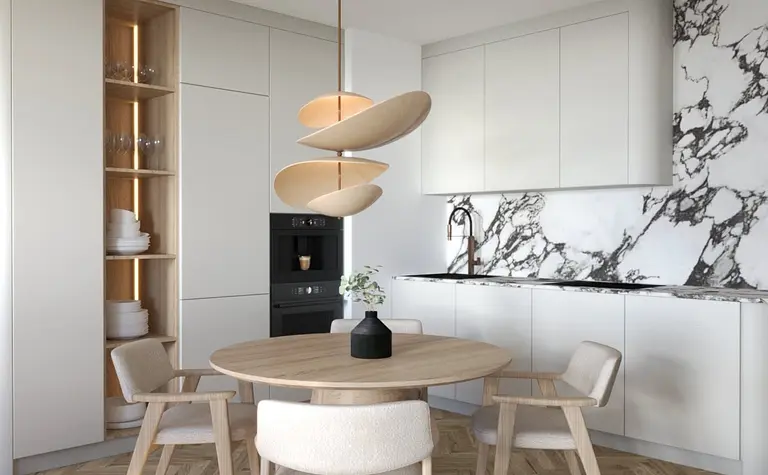 Nowoczesna kuchnia z jasnym, drewnianym stołem i designerską lampą wiszącą. Marmurowy backsplash z wyrazistym wzorem oraz zabudowane szafki nadają wnętrzu elegancji.