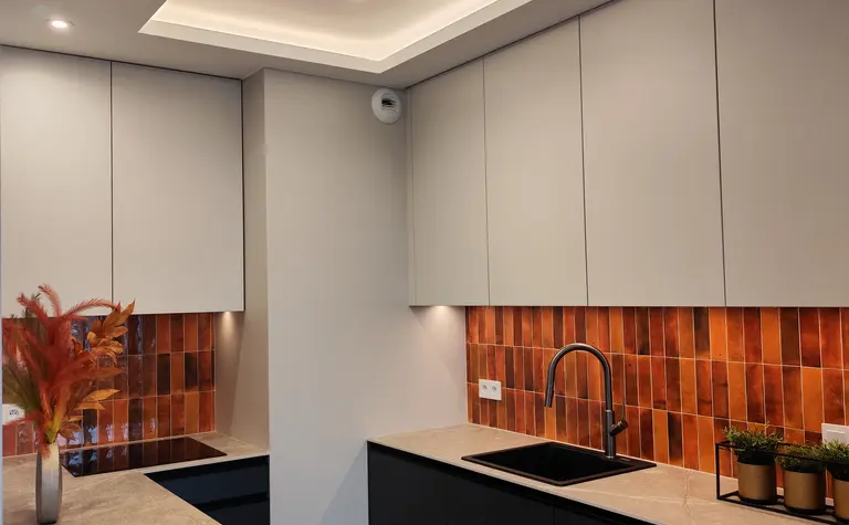 Kuchnia z minimalistycznym wystrojem, nowoczesnymi meblami oraz akcentami w stylu soft minimalizm.