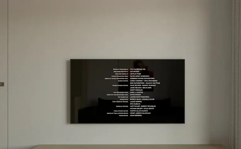 Minimalistyczny salon z nowoczesnym telewizorem i drewnianymi meblami.