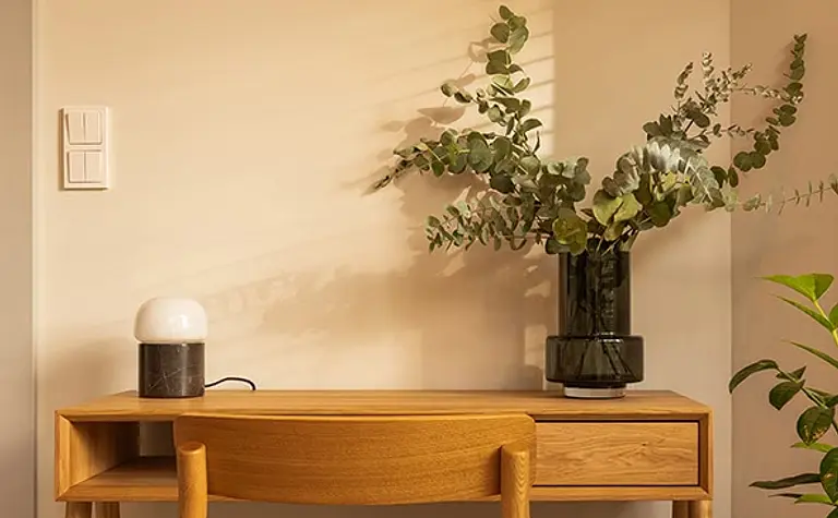 Minimalistyczne biuro z drewnianym biurkiem i roślinami