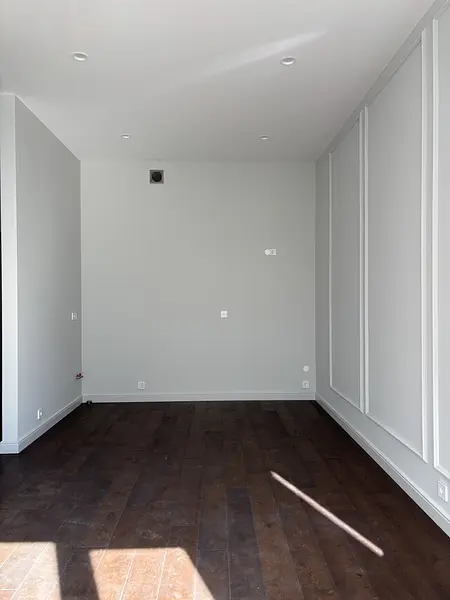 Wnętrze z szarymi ścianami i drewnianą podłogą, nowoczesny soft minimalizm.