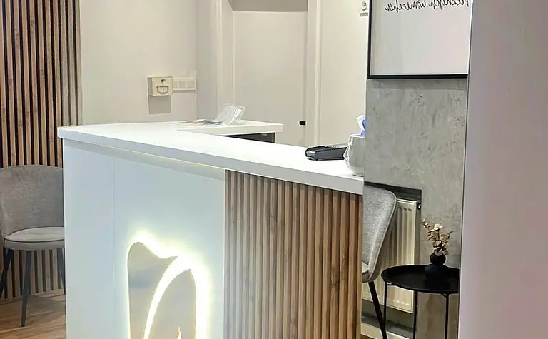 Recepcja w stylu industrialnym z drewnianymi detalami i białymi elementami.