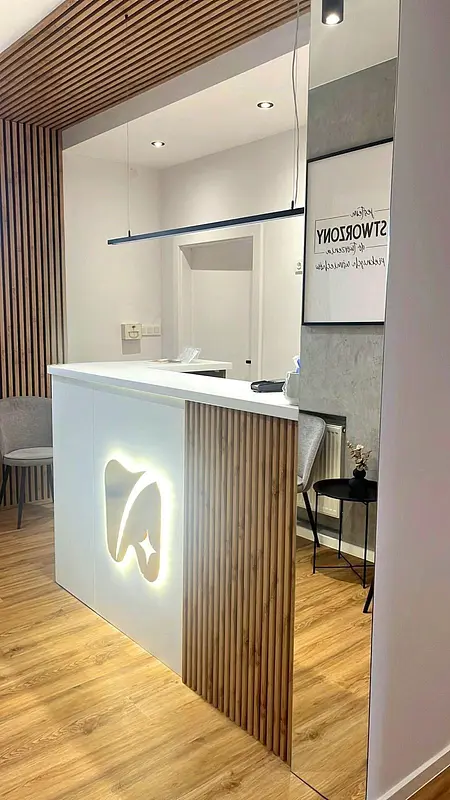 Recepcja w stylu industrialnym z drewnianymi detalami i białymi elementami.