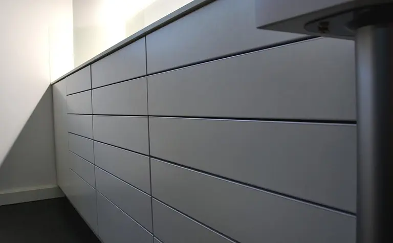 Minimalistyczne wnętrze z szarymi meblami w nowoczesnym stylu minimaluxe.