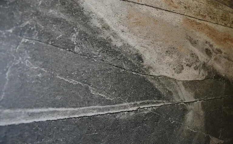 Ściana z szarym i białym kamieniem w minimalistycznym wnętrzu.