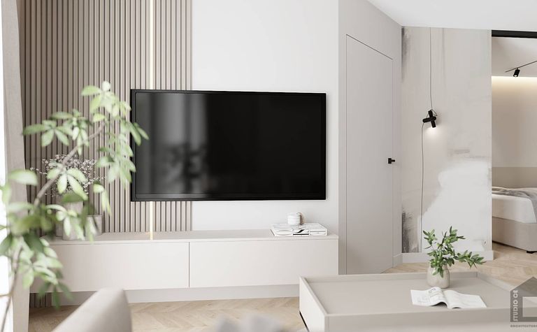 Wnętrze salonu z telewizorem, białymi meblami i zielonymi roślinami, styl glamour i nowoczesny.