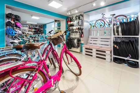 Sklep rowerowy z różowymi rowerami i akcesoriami, styl boho
