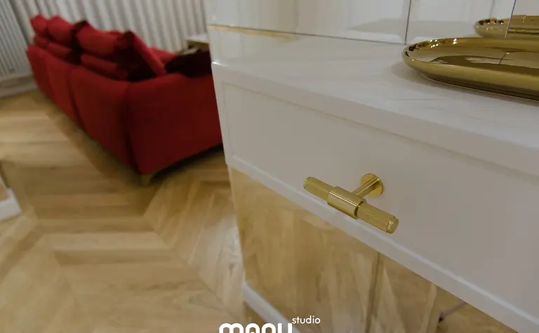 Nowoczesny salon z czerwonymi sofami i złotymi akcentami, tradycyjny design.