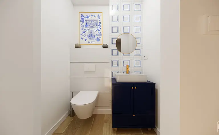 Wnętrze łazienki z niebieskimi płytkami, białą umywalką i drewnianą podłogą, styl dopamine decor, eklektyczny, skandynawski.