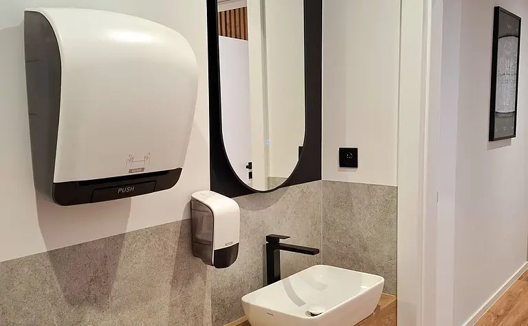 Toaleta z drewnianą półką, umywalką i lustrem w stylu industrialnym, nowoczesnym, skandynawskim, współczesnym.