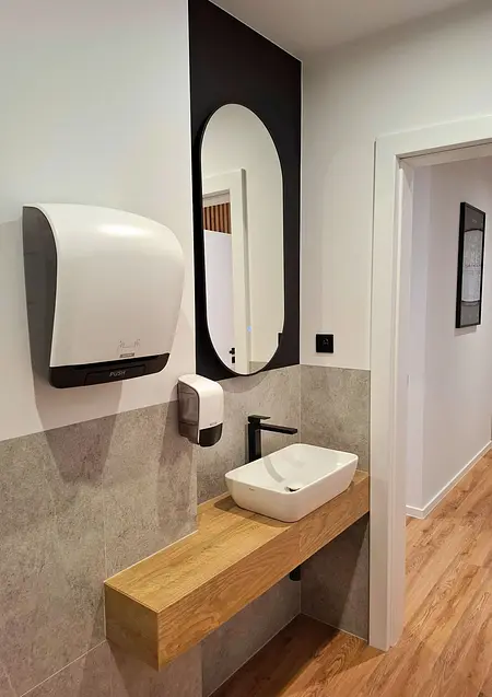 Toaleta z drewnianą półką, umywalką i lustrem w stylu industrialnym, nowoczesnym, skandynawskim, współczesnym.