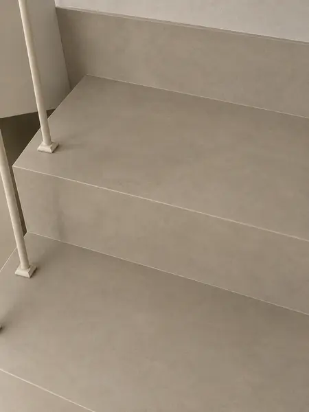 Beżowe schody z białymi balustradami w stylu art deco, industrialnym i minimalistycznym.