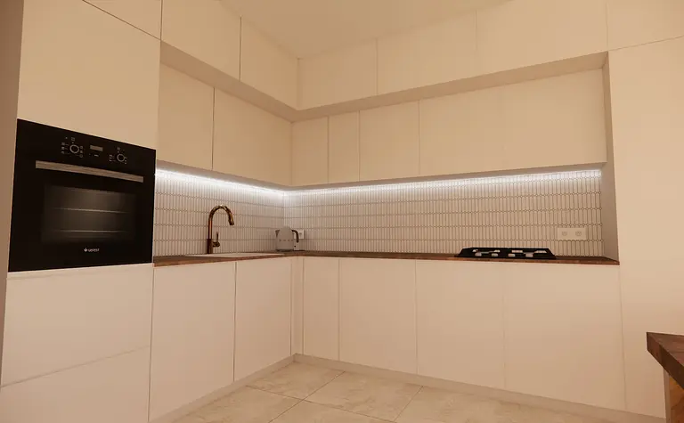 Kuchnia minimalistyczna z białymi meblami i nowoczesnym sprzętem.
