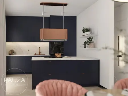Kuchnia z granatowymi meblami, marmurowym blatem i różowym fotelem, nowoczesny design.
