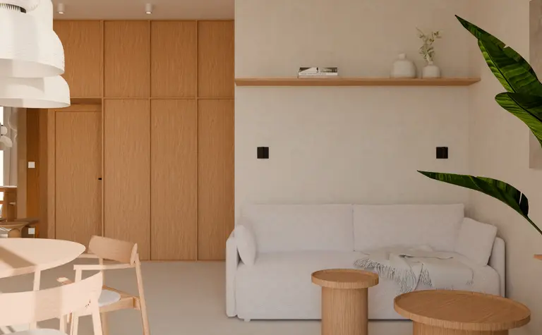 Wnętrze w stylu japandi z jasną sofą i drewnianymi akcentami.
