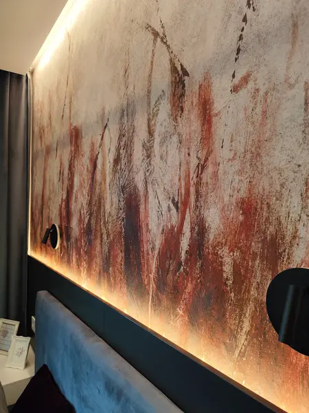 Wnętrze sypialni z minimalistycznym designem, nowoczesną ścianą w odcieniach brązu i oświetleniem LED.