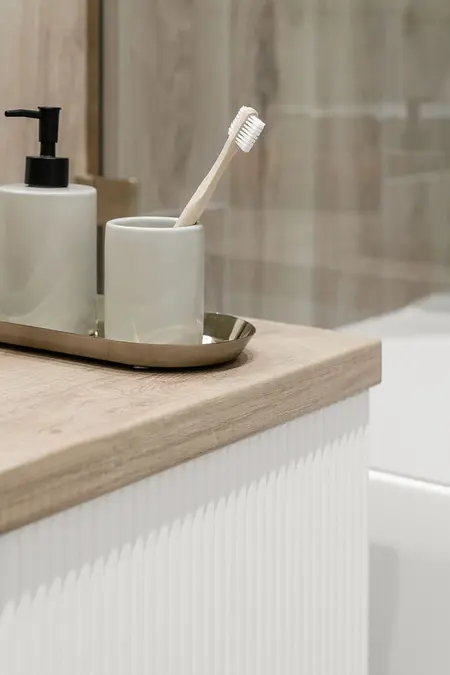 Współczesna łazienka z drewnianym blatem i akcesoriami do pielęgnacji.