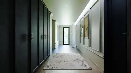 Przedpokój z elementami art deco i współczesnymi, z czarnymi szafami i jasnymi ścianami.