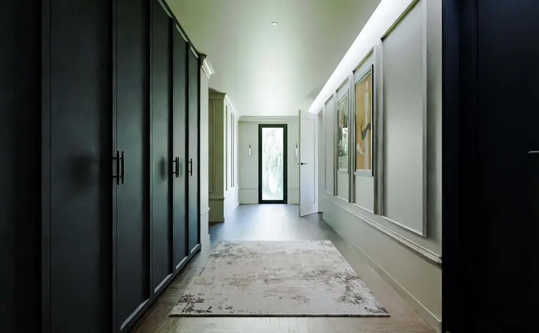 Przedpokój z elementami art deco i współczesnymi, z czarnymi szafami i jasnymi ścianami.