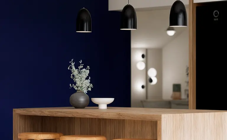 Wnętrze kuchni z drewnianym blatem, czarnymi lampami i niebieską ścianą, styl dopamine decor.