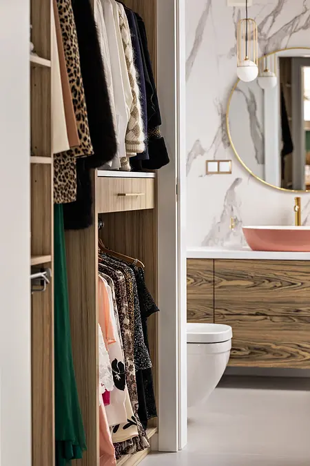 Garderoba z drewnianymi półkami i modnymi ubraniami. Styl art deco, boho, glamour.