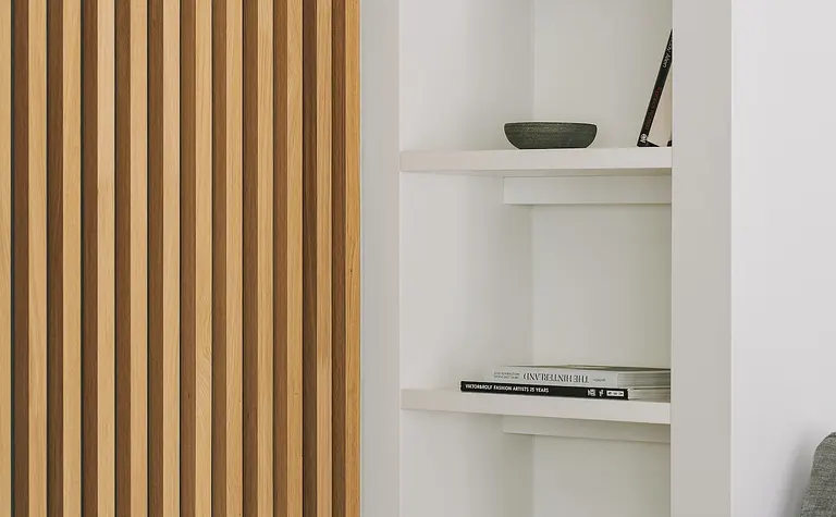 Wnętrze z drewnianą ścianką, białymi półkami i minimalistycznym designem.