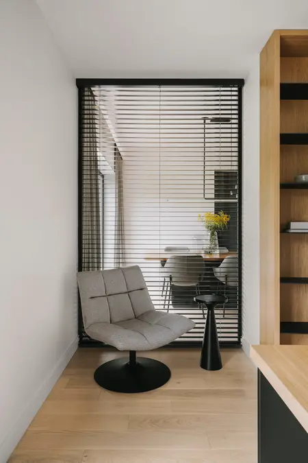 Wnętrze z industrialnym i minimalistycznym kącikiem do pracy z szarym fotelem.