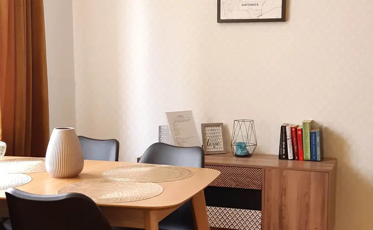 Wnętrze jadalni z drewnianym stołem, czarnymi krzesłami i tradycyjnym wystrojem