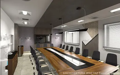 Wnętrze sali konferencyjnej z dużym stołem, nowoczesnymi krzesłami i oświetleniem.