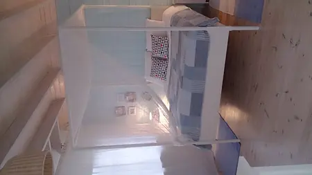 Sypialnia w stylu boho z białym łóżkiem, niebieską pościelą i rustykalnym wnętrzem.