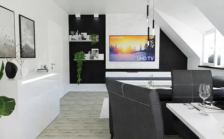 Nowoczesne wnętrze z czarną sofą, białym stolikiem i roślinnością.