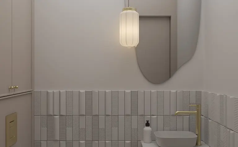 Nowoczesna łazienka z szarymi kafelkami, złotym kranem i okrągłym lustrem.