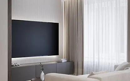Wnętrze salonu w stylu minimalistycznym z jasną sofą, telewizorem i zasłonami.