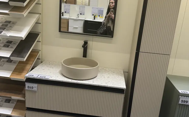 Wnętrze łazienki z jasnymi meblami i lustrem.