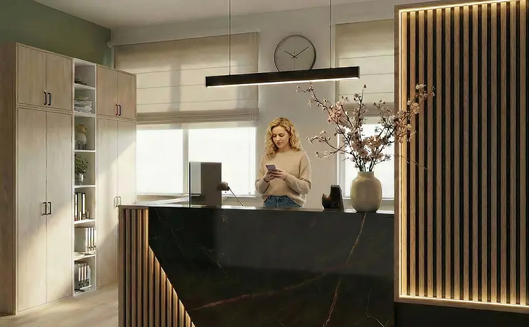 Wnętrze kuchni z drewnianymi meblami, czarnym blatem i roślinami.