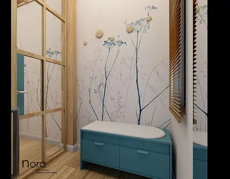 Przedpokój z niebieską komodą, drewnianymi detalami i roślinnymi wzorami na ścianie.