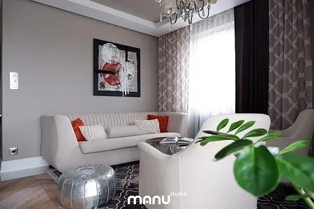 Nowoczesny salon z jasną sofą, czerwonymi poduszkami i dekoracyjnym obrazem. Styl tradycyjny.