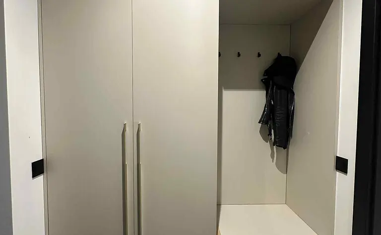 Garderoba w stylu industrialnym i nowoczesnym z beżowymi meblami.