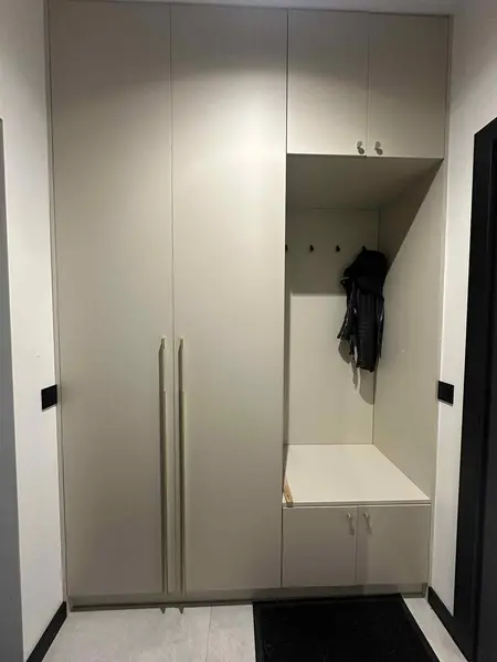 Garderoba w stylu industrialnym i nowoczesnym z beżowymi meblami.