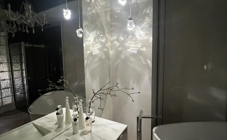 Elegancka łazienka z białą wanną i stylowymi lampami w stylu glamour.