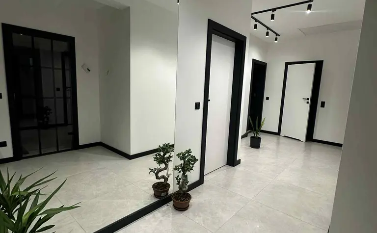 Przedpokój w stylu industrialnym i nowoczesnym z białymi ścianami i roślinami.
