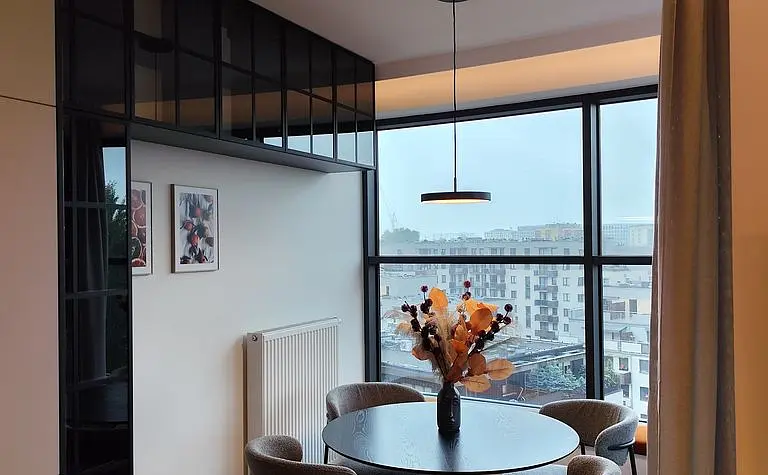 Wnętrze salonu w stylu prowansalskim z zieloną sofą i drewnianymi meblami.