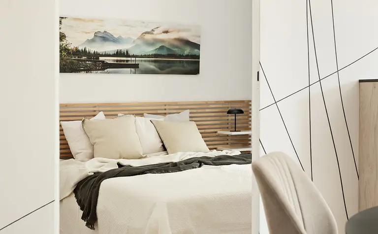 Wnętrze sypialni z minimalistycznym designem, nowoczesne meble i spokojna kolorystyka.