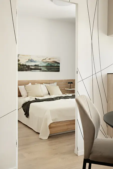 Wnętrze sypialni z minimalistycznym designem, nowoczesne meble i spokojna kolorystyka.