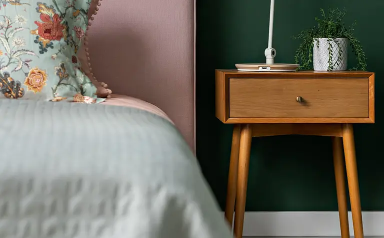 Sypialnia z różowym łóżkiem, zieloną ścianą oraz dodatkami w stylu art deco, boho, glamour.